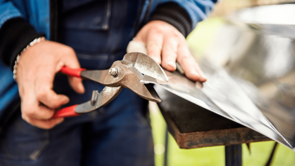 Close up of hands cutting metal